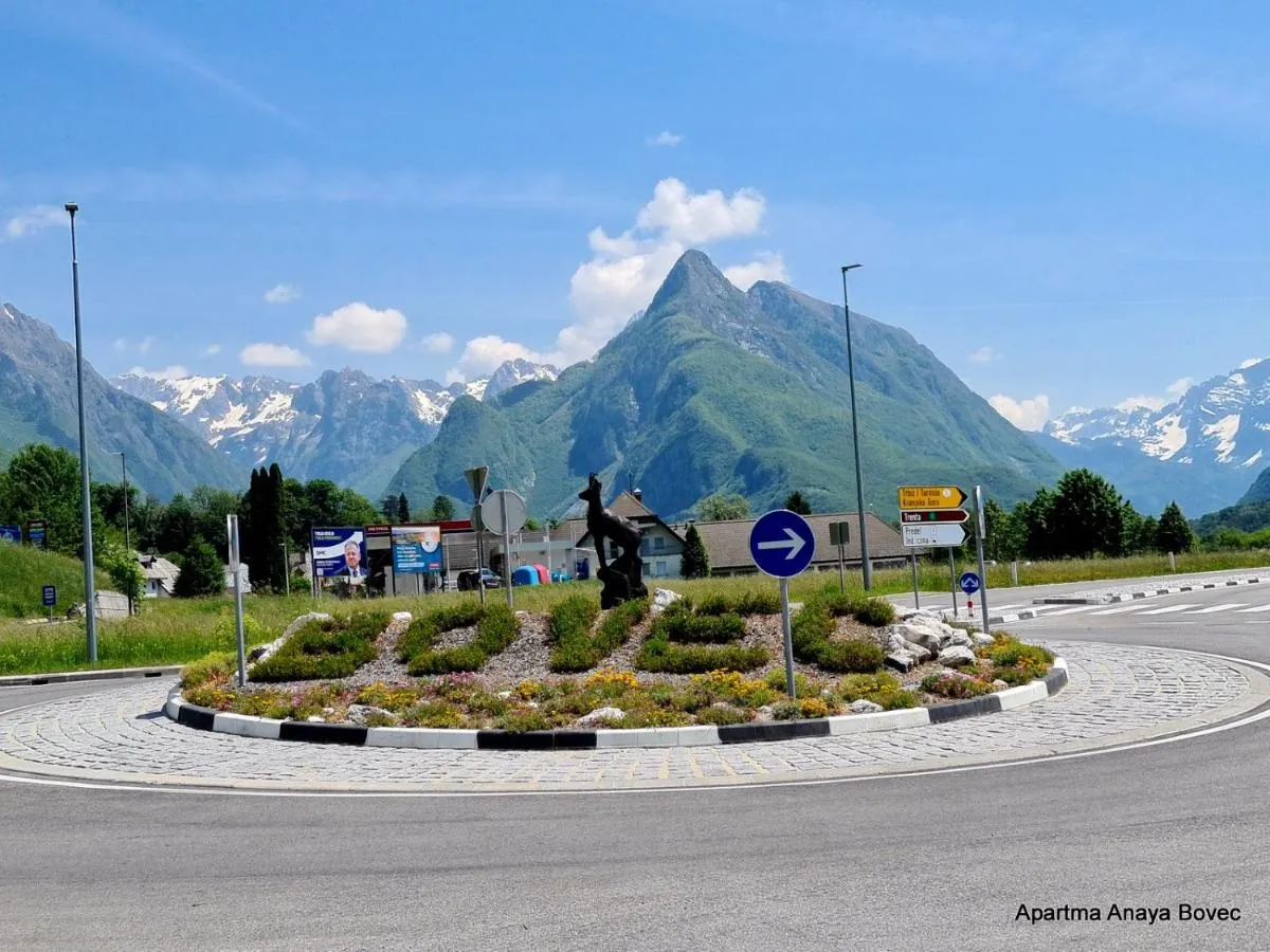 Krožišče z napisom Bovec, zadaj gore